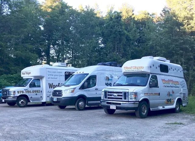 The Woof Wagon mobile grooming fleet — three vans ready to roll
